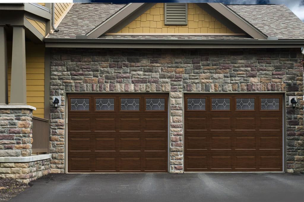 Madera Series wood-look garage doors on a stone and stucco Pueblo home